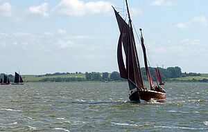 Ein altes Zeesboot fährt auf dem Wasser.