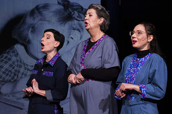 Drei Schauspielerinnen stehen nebeneinander auf der Bühne.