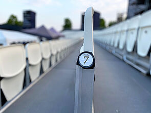 Leere Sitzreihen. Eine Plakette zeigt Reihe 7 an.