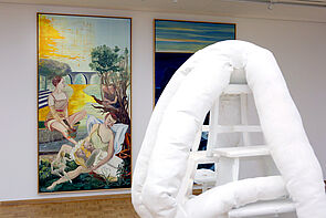 Blick in die Ausstellung. Zwei Bilder und ein Kunstobjekt sind zu sehen.