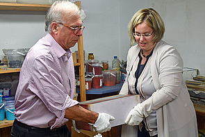 Zwei Mitglieder der Kunstkommission tragen gemeinsam einen Gipsblock. 