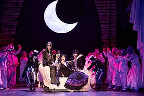 Gruselig verkleidete Schauspieler auf der Bühne. Hinten leuchtet der Mond.