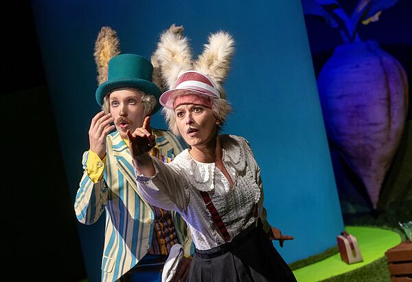 Zwei Menschen spielen Theater. Einer als Igel verkleidet. Der andere als Hase.