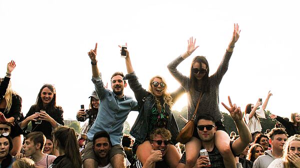 Ein Bild voller Jugendlicher. Sie lachen. Einige reißen die Arme hoch.