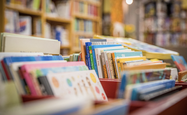 Blick in einen Bibliotheksraum. Auf volle Bücherkisten und Bücherregale. Ein Symbolbild.