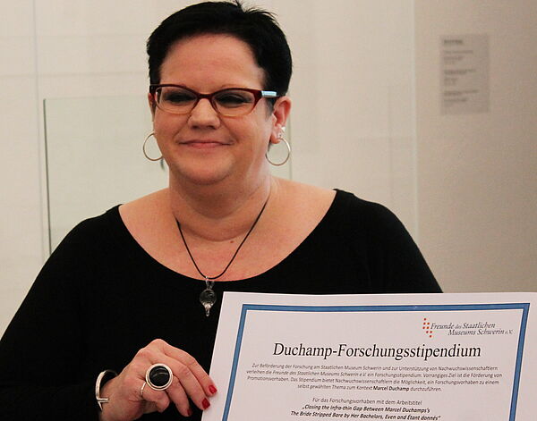 Jill O'Connor hält die Urkunde für das Stipendium in ihrer Hand.