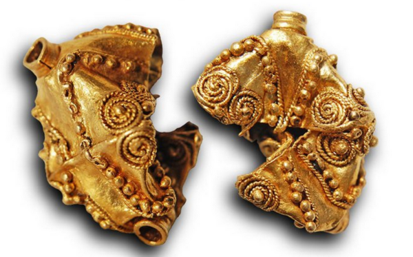 Zwei goldene Teile mit Schmuckelementen.