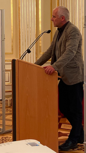 Ein Mann steht an einem Rednerpult und spricht.