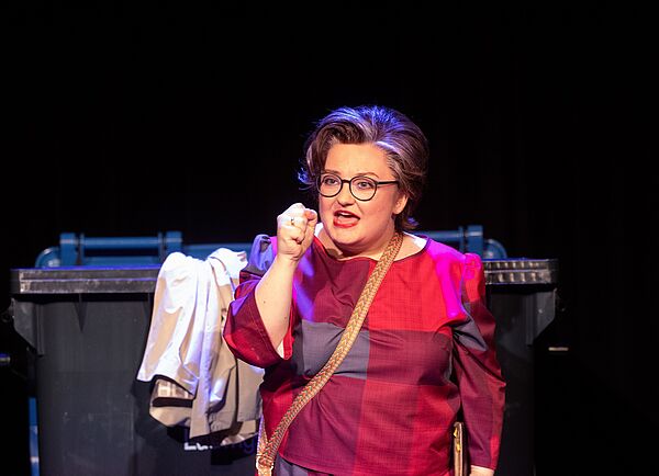 Eine Frau mit einer Brille spricht gestikulierend.