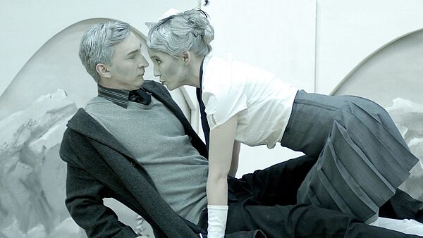 Das Foto zeigt eine Frau, die auf einem Mann kniet.