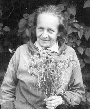 Ein Schwarz-Weiß-Foto von Käthe Miethe mit einem Blumenstrauß in der Hand.