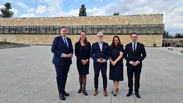 Gruppenbild mit fünf Politikerinnen und Politikern vor der Gedenkstätte Yad Vashem.