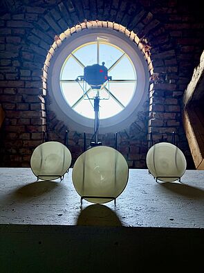 Teller stehen im Dunkeln. Im Hintergrund scheint Licht durch ein Fenster.