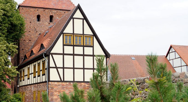 Ein Fachwerkhaus hinter Bäumen.