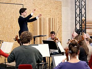 Blick ins Orchester. In der Mitte: der Dirigent.