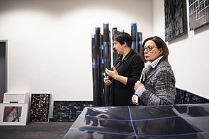 Monika Bertermann steht mit einer Frau der Kunstkommission neben ihren Kunstwerken.