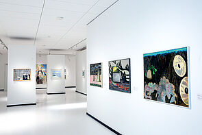 Bilder in bunten Farben hängen an den Wänden.