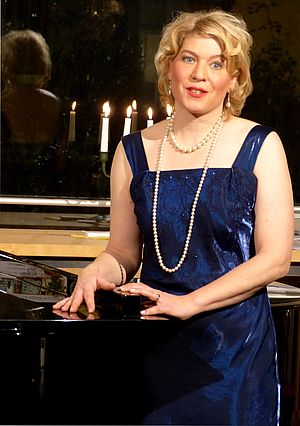 Britta Kopelke steht an einem Klavier.