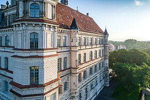 Ein Luftbild vom Schloss auf Höhe der zweiten Etage mit Blick auf die helle Fassade.