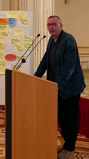 Ein Mann steht an einem Rednerpult und spricht.