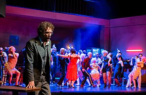 Hinten feiert die Menge. Vorn im Bild grübelt ein Mann.