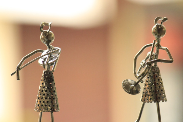 Zwei dünne Figuren aus Metall. Eine spielt Geige, die andere Trompeter.