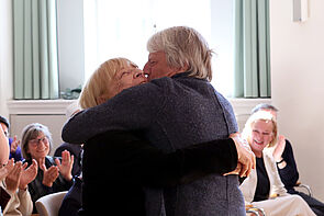 Ein Sohn herzt seine Mutter.