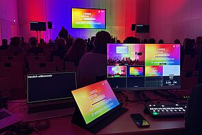 Bildschirme zeigen die Bühne der Konferenz.