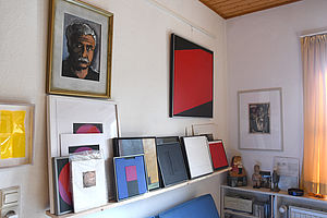 Ein kleiner Raum mit Bildern von Helmut Senf.
