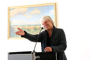 Ein Mann steht am Mikro und hält eine Rede.