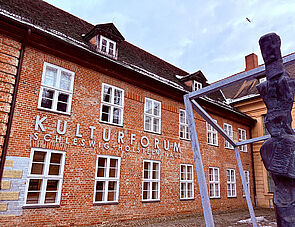 Ein Fachwerkhaus. An der Fassade steht: Kulturforum Schleswig-Holstein-Haus.