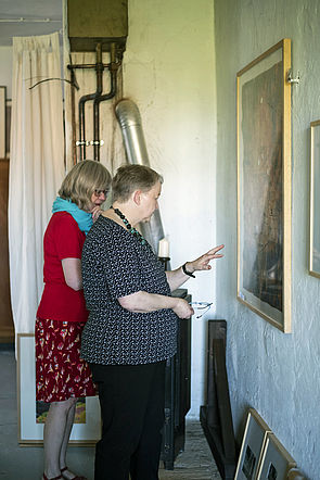 Zwei Mitglieder der Kunstkommission stehen vor einem großen Bild.
