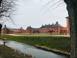 Ein kleiner Wasserkanal im Schlossgarten. Im Hintergrund: Schloss Bothmer.