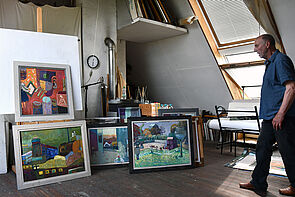 Heinke Holm in seinem Atelier. An der Wand lehnen kleinformatige Malereien.