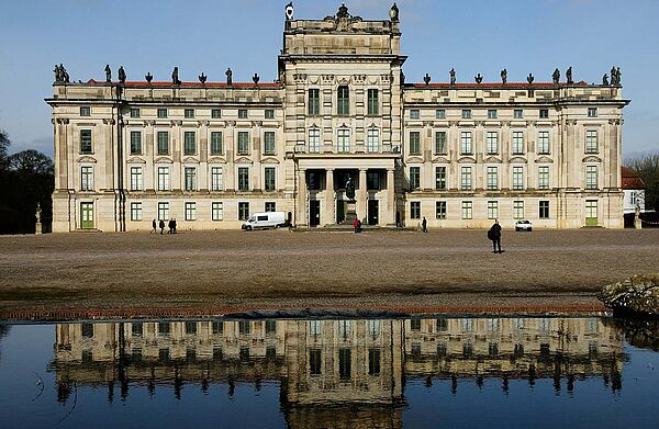 Die Außenfassade des Schlosses spiegelt sich im Schlossgraben. 