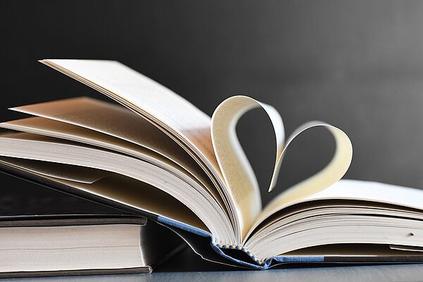 Ein aufgeschlagenes Buch. Die beiden Mittelseiten sind so gefaltet, dass sie ein Herz ergeben.