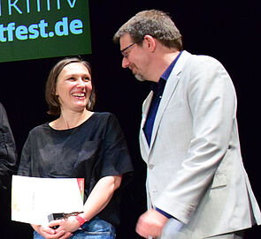 Ein Mann und eine Frau stehen nebeneinander. Sie unterhalten sich. 