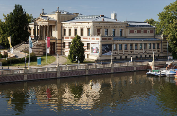 Das Staatliche Museum Schwerin. Fotografiert von der Schlossinsel. Das Gebäude spiegelt sich im Wasser.