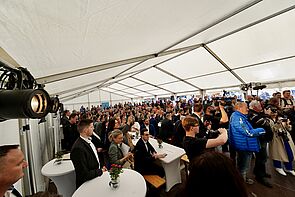 Zahlreiche Menschen in einem Zelt.