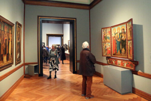 Gäste im Museum betrachten die Gemälde.
