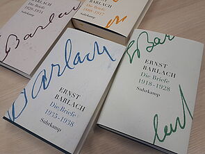 Die vier Briefbände liegen nebeneinander auf einem Tisch.