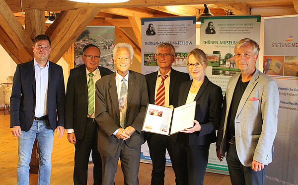 Angela Ziegler steht in einer Reihe Sebastian Constien, Prof. Fritz Tack, Rolf-Peter Bartz, Andreas Parlow und Henry Tesch. Die Preisträgerin hält eine Urkunde in der Hand.