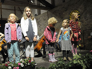Fünf Kinder stehen nebeneinander auf einer Bühne.