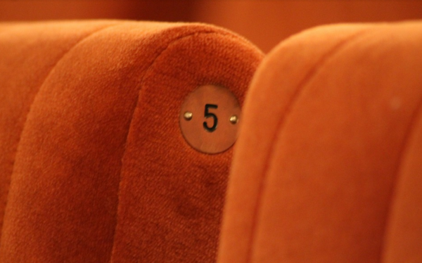 Zwei orangefarbene Kino- oder Theatersessel.