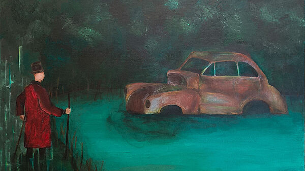 Es ist Nacht. Ein Auto steht im Wasser. Am Ufer steht ein Mann. Er schaut auf das Wasser. 