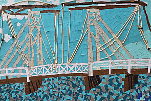 Bunte Papierschnipsel. Sie wurden aneinandergeklebt und ergeben eine Brücke.