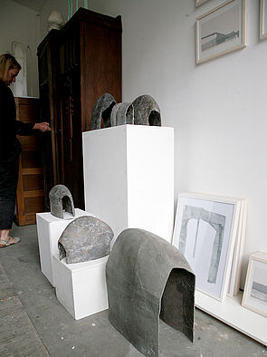 Auf dem Boden sowie auf weißen Sockeln stehen Büsten.