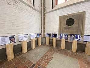 Neun Holzstelen. Darauf befinden sich Informationstafeln zum Dom und zu den geplanten Uecker-Fenstern.