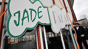 An der Außenfassade hängt ein Schild mit der Aufschrift "Jade Palast"