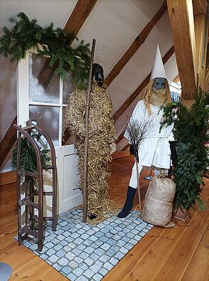 Ein alter Schrank mit einem Schlitten und einer Schaufensterpuppe in einem weißen Anzug, die an den Weihnachtsmann erinnert.